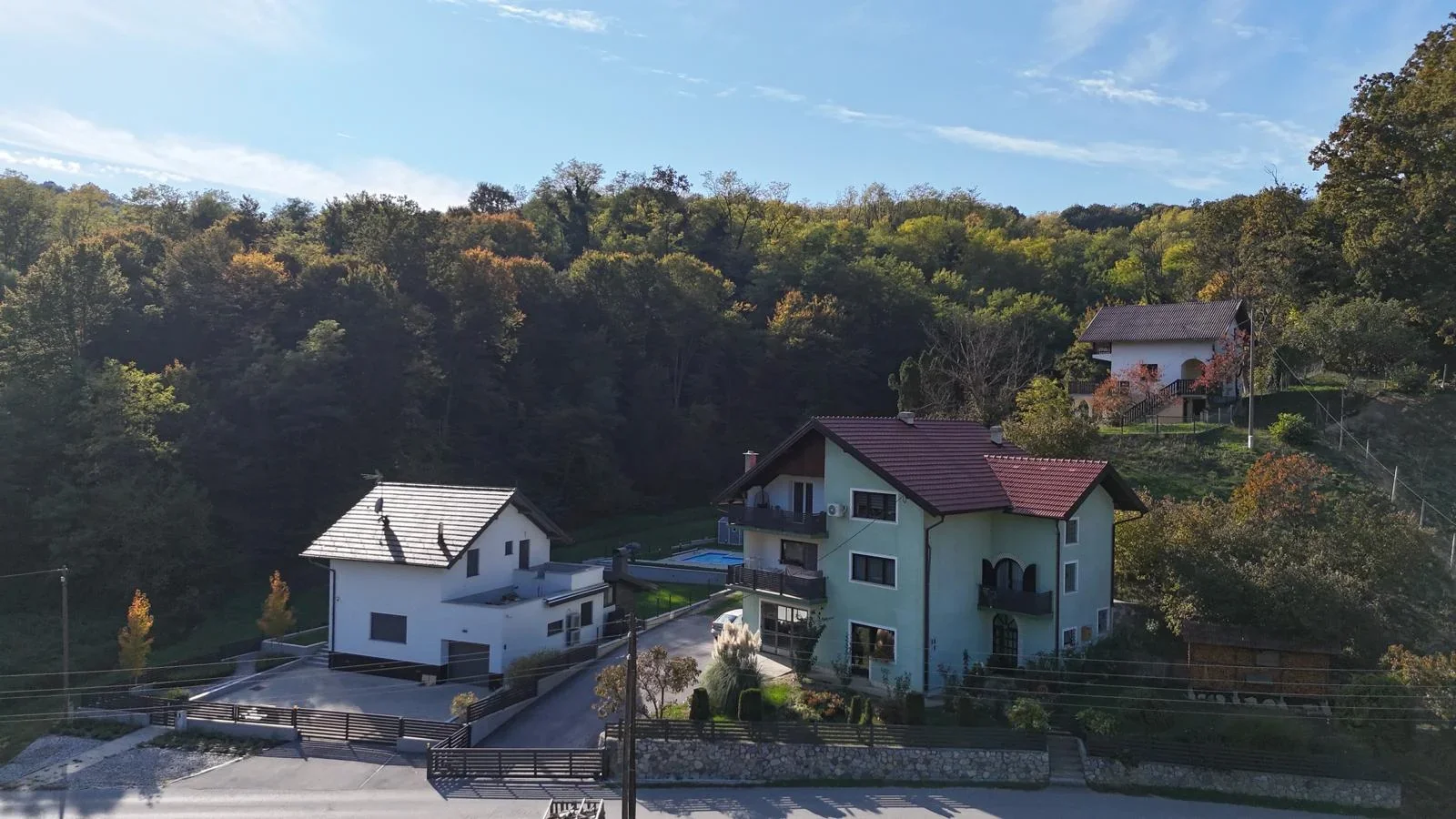 Kuće s aluminijskim ogradama uz cestu – snimka iz zraka